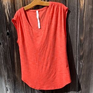 Lululemon Coral / pink orange V neck shirt.  Lightweight with ruched shoulders.